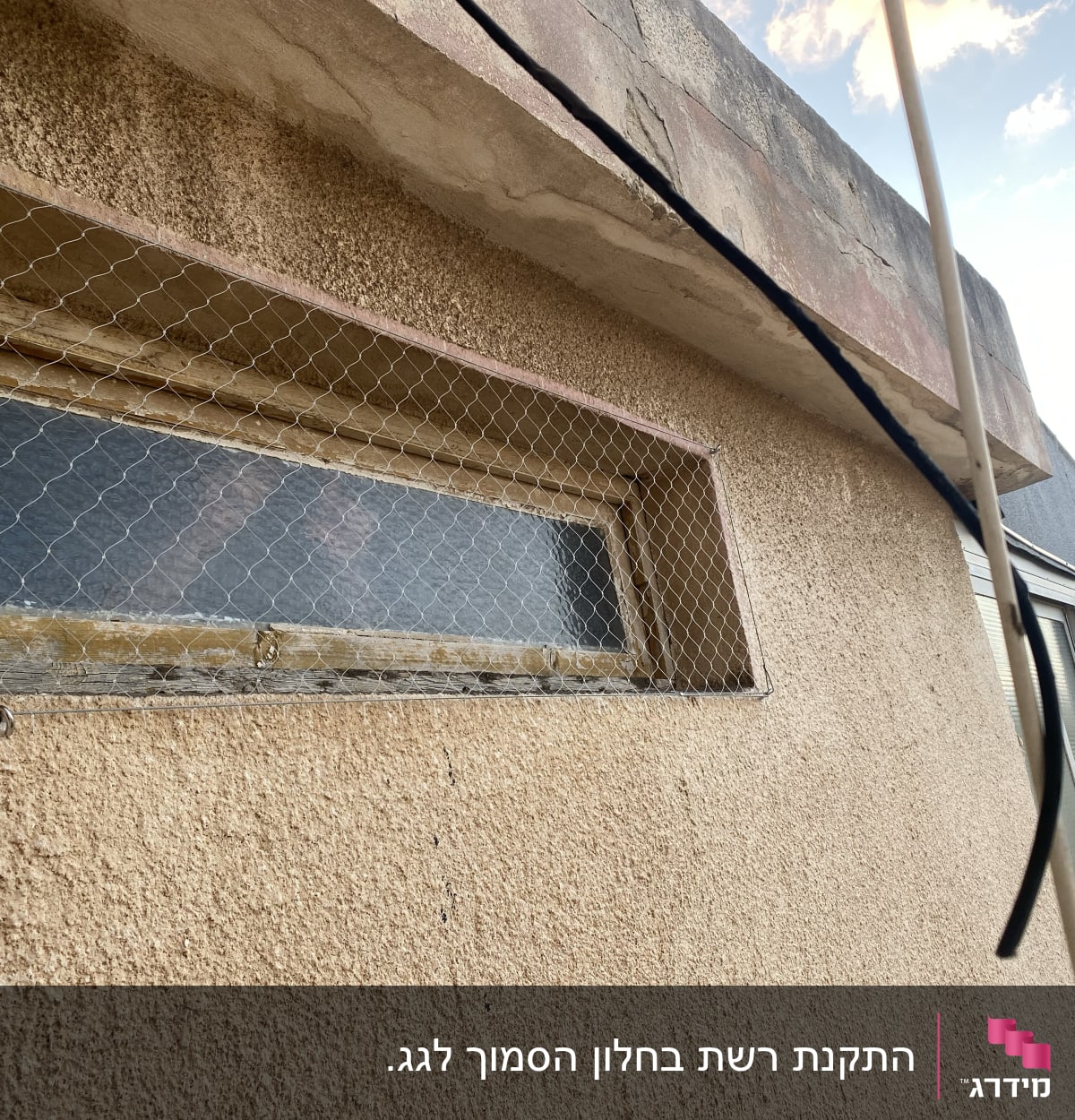 רשת מתכת מותקנת על חלון למניעת כניסת יונים